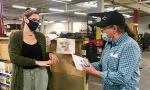 LPC Executive Assistant, Kim Baker is shown handing grand prize winner, Larry Doner his certificate for a paid day off.